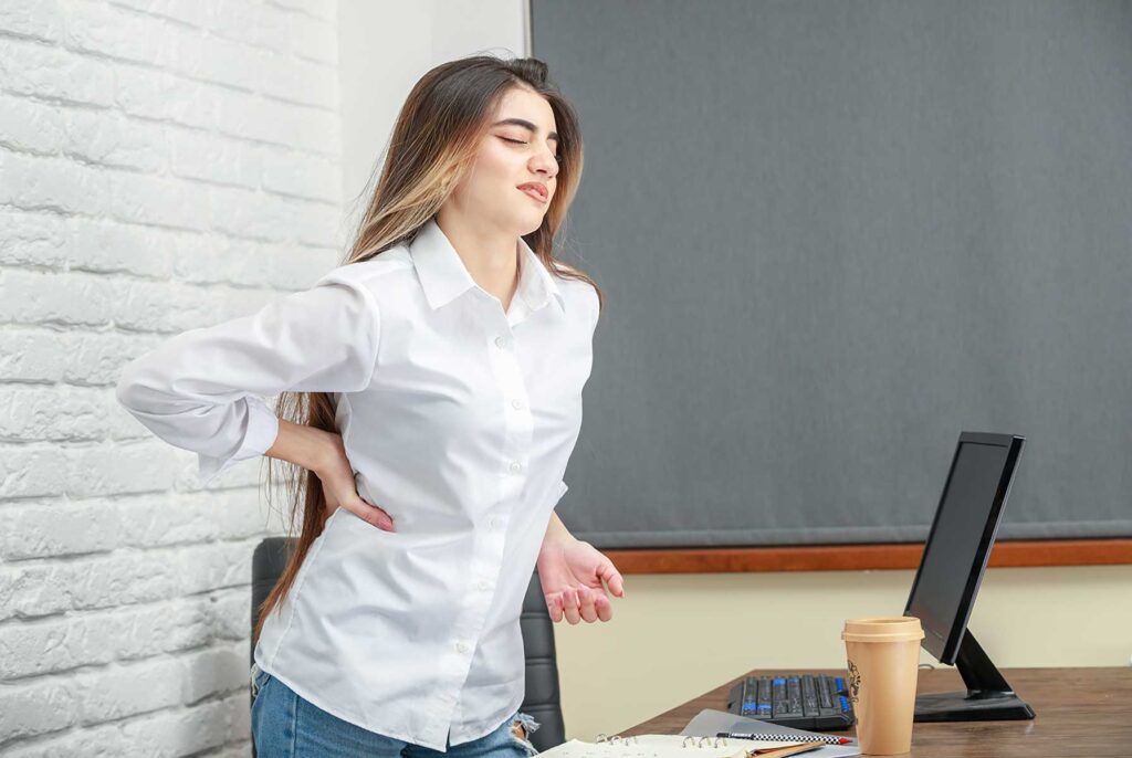 Image showing a woman experiencing lower back pain, seeking relief through yoga poses.