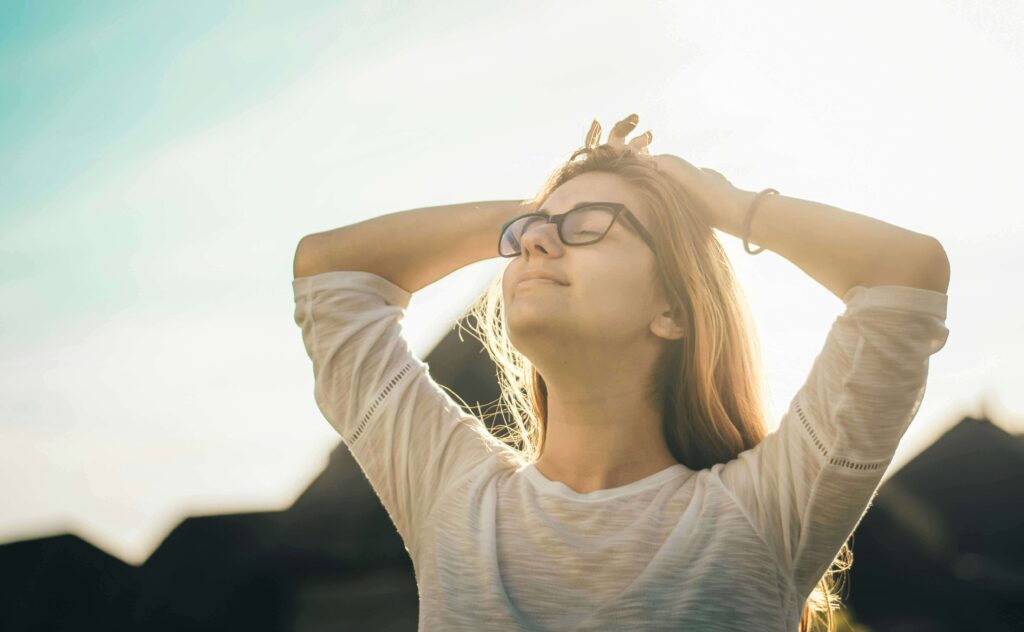 A happy woman smiling, symbolizing the relief and joy experienced after stress management.