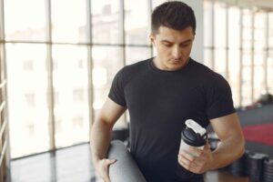 Man considering the Pre-Workout Supplements Affect Male Fertility, with healthy food options nearby.