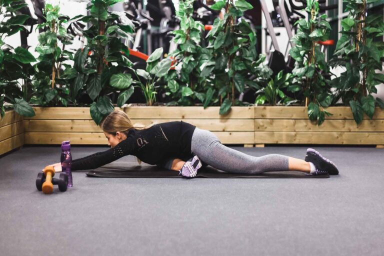 Woman doing exercise for fix flared ribs, with a focus on strengthening the core and upper back muscles.